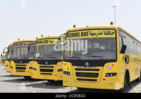 A row of yellow school buses in Dubai parked and not in use due to Covid-19 related school closures Stock Photo