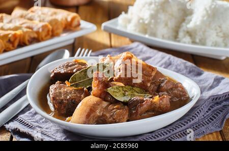 filipino pork adobo in bowl with rice in background Stock Photo