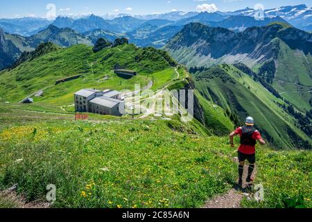 Man starting a trail run descent in Swiss Alps and panorama of mountains during summertime in Switzerland Europe Stock Photo