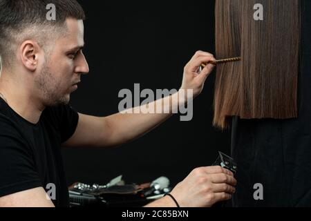 Barber or stylist at work. Hairdresser cutting woman hair Stock Photo