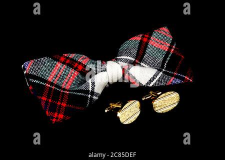 Plaid bow tie and cufflinks isolated against a black background Stock Photo
