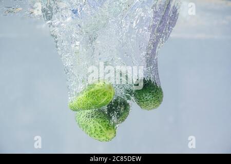 cucumbers fall into the water with bubbles Stock Photo