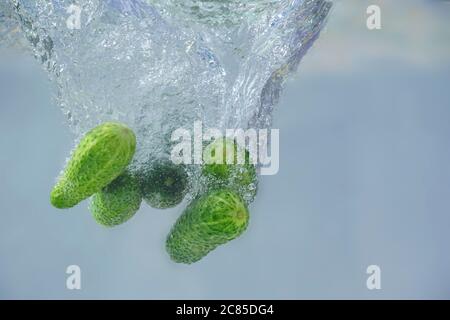 cucumbers fall into the water with bubbles Stock Photo
