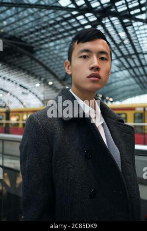 Young stylish Asian businessman confidetly looking in camera at metro station Stock Photo