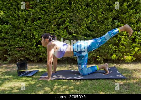 Beautiful young woman doing yoga in the garden Stock Photo