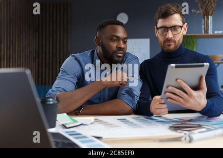 Multiracial engineer team working in office with tablet PC. Architects select colors for building using color swatches, sketching and planning Stock Photo