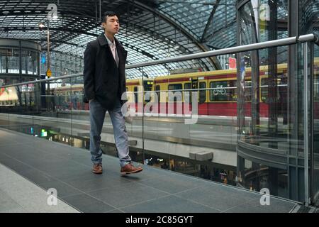 Young stylish Asian businessman confidently walking through subway station Stock Photo