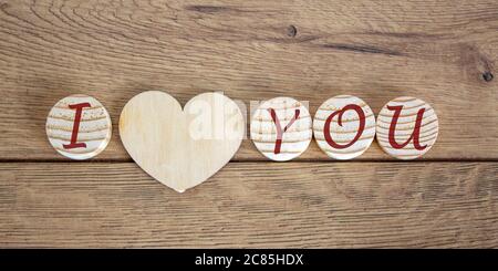 Concept letters I and U made on wooden circles. Wooden heart. Stock Photo