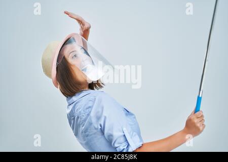 Woman tourist wearing protective shield taking selfie on white background Stock Photo