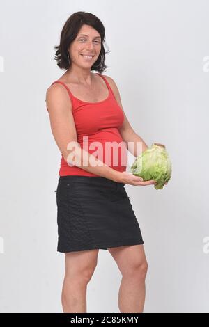 pregnant woman holding lettuce on white background Stock Photo