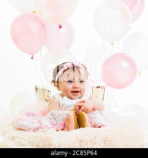 Square lifestyle portrait of a baby girl's first birthday. Stock Photo