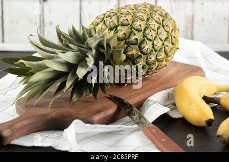 A whole pineapple on the wooden cutting board Stock Photo
