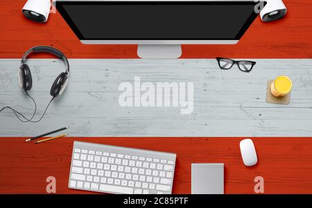 Austria flag background with headphone,computer keyboard and mouse on national office desk table.Top view with copy space.Flat Lay. Stock Photo