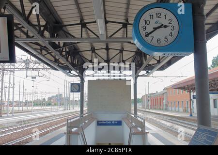 train station, italy - summer 2020: a big blue clock over the binary near the exit in train station Stock Photo