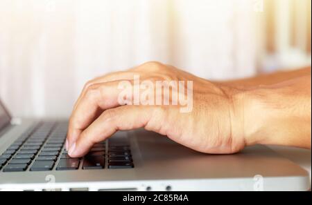 Close up man Finger using laptop keyboard Man working with laptop at home. man using laptop, searching online web browser information. soft focus pict Stock Photo