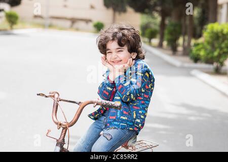 Sweet little baby boy riding a bicycle in the park Stock Photo