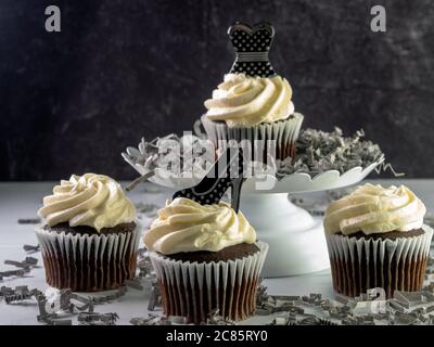 Chocolate cupcakes with white swirled frosting decorated with a black Stock Photo