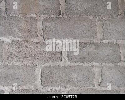 Closeup shot of the wall made up of gray rectangular stones and concrete Stock Photo