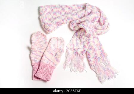 Knitted scarf and mittens in delicate white, pink and lilac colors on a white background. Stock Photo