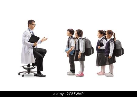Male pediatrician doctor sitting and talking to a group of schoolchildren isolated on white background Stock Photo