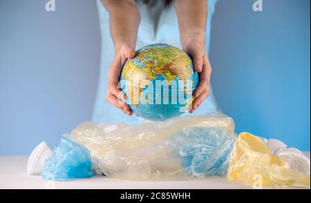 https://l450v.alamy.com/450v/2c85whh/a-woman-is-pulling-out-an-earth-in-form-globe-of-a-pile-of-plastic-garbage-concept-of-environmental-pollution-and-saving-the-planet-2c85whh.jpg