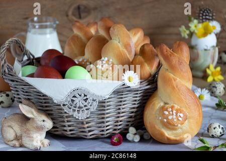 easter table decoration with yeast easter bunnies and eggs in basket Stock Photo