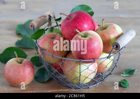 fresh apples in basket on wooden table Stock Photo
