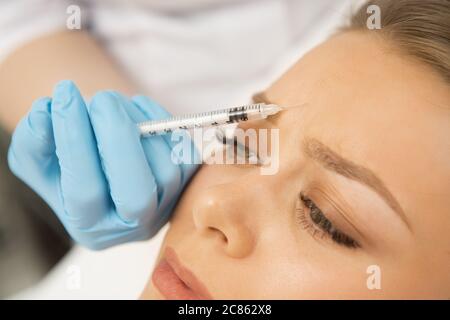 Close up of a professional cosmetologist making botox injection in the face of her female client. Beautiful woman getting facial treatment at the clin Stock Photo