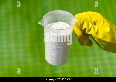 addition of chlorine powder for the pool to remove algae and disinfect water. inflatable swimming pool care concept. Stock Photo