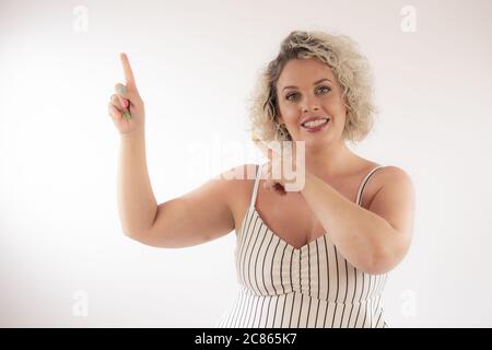 Blonde young woman pointing something with her fingers Stock Photo