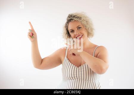 Blonde young woman pointing something with her fingers Stock Photo