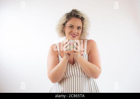Blonde young woman drinking a cup of coffee Stock Photo