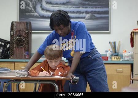 Pflugerville, Texas USA, November 2005: Black teacher interacts with student in sixth grade World Cultures classroom in suburban school district outside of Austin. ©Bob Daemmrich Stock Photo
