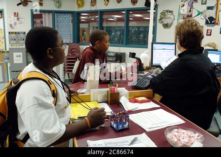 Pflugerville, Texas USA, November 2005: Seventh-grade students and librarian at checkout desk in middle school library in suburban school district outside of Austin. ©Bob Daemmrich Stock Photo