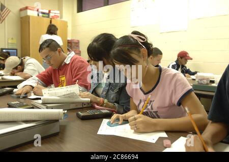 Brownsville, Texas USA, December 2 2005: Students at Lopez High School work on math problems in Algebra II classroom using hand-held scientific calculators. The student population of Lopez HS is over 99% Hispanic.  ©Bob Daemmrich Stock Photo