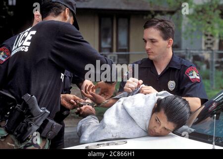 Austin, Texas USA, 2006: Three Anglo police officers apprehend Hispanic juvenile male in Austin. ©Bob Daemmrich Stock Photo