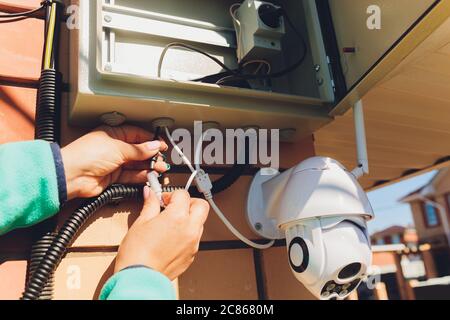 technician female setup cctv camera on wall. Stock Photo