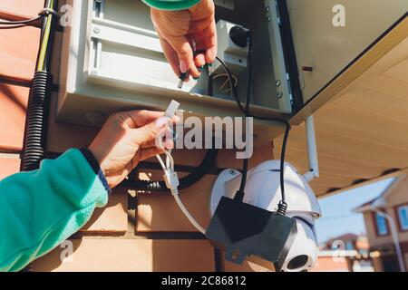 technician female setup cctv camera on wall. Stock Photo