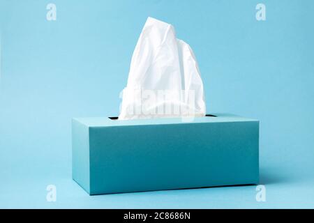 Light blue tissue box on blue background. Cold and flu concept. Minimal monochromatic composition. Stock Photo