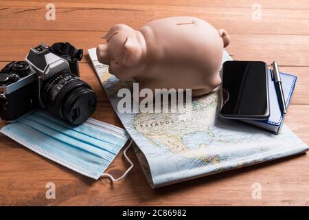 Conceptual still life with various objects related to travel and mask, on wooden boards. Travel concept during the covid19 coronavirus pandemic. Stock Photo