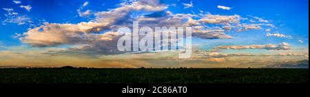 Bright sunlight shining through the clouds against the backdrop of a breathtaking evening sky at sunset. panorama, natural composition Stock Photo
