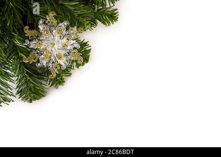 Christmas Toy snowflake On The Christmas Tree. Beautiful closeup of a snowflake and other decorations on a Christmas tree with lights Stock Photo