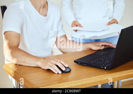close up of couple with bill document paying on laptop in home Stock Photo
