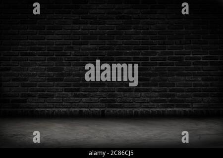 Empty black brick wall and concrete floor for background. Dark room interior with black brick wall blank cement floor for backdrop. Stock Photo