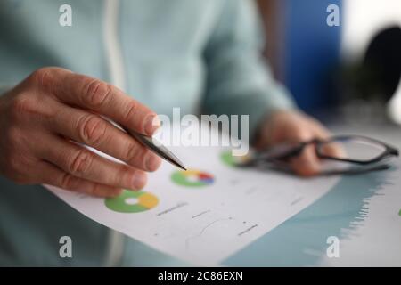 Male hand holding paper with financial statistics Stock Photo