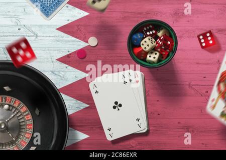 Bahrain casino theme. Aces in poker game, cards and chips on red table with national flag background. Gambling and betting. Stock Photo