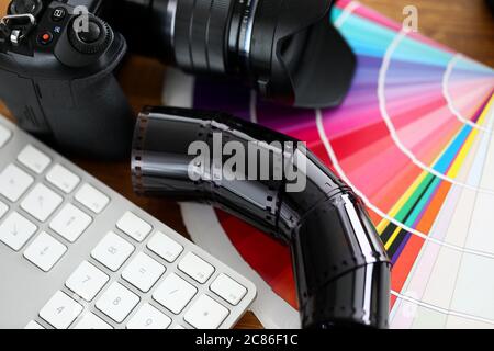 Old film tape laying on colourful fantail with silver keyboard Stock Photo