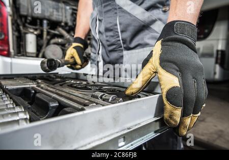 Caucasian Mechanic Selecting Right Tools For the Repair Job. Professional Garage Tools. Automotive Industry Theme. Stock Photo