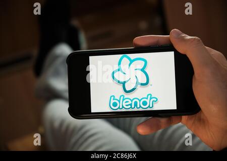 Blendr application on the smartphone in mans hand. Man laying and using application for dating and meeting. Social network concept, July 2020, Prague Stock Photo