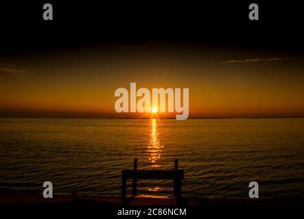 Setting sun spreads over river water. Stock Photo